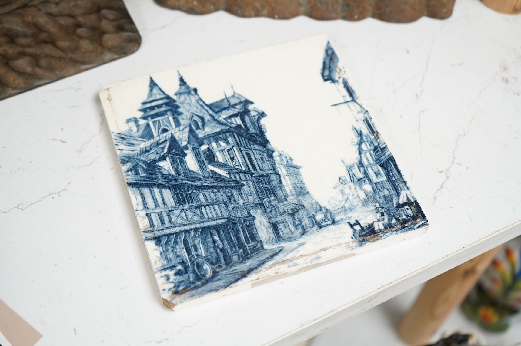 A Minton blue and white tile and two cast iron door stops, one in the form of a sheep, 24cm wide